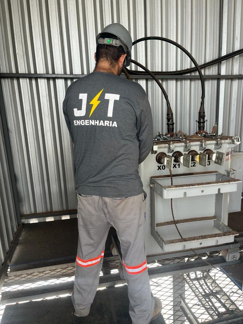 Engenheiro da JT Engenharia Elétrica inspecionando transformador industrial